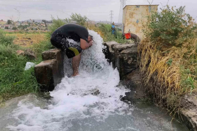 Kavurucu sıcakta elbisesini bile çıkarmadan buz gibi sondaj suyunda serinledi

